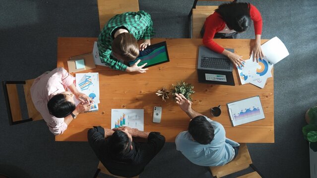 Time lapse of diverse business people working together to analyze chart. Top down aerial view of creative team looking at stock market report and discussing about financial investment. Convocation. - Powered by Adobe