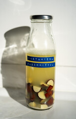 Homemade natural detergent made from chestnuts in a glass bottle. DIY eco-friendly cleaning product using chestnuts as a natural source of saponins.German label visible.