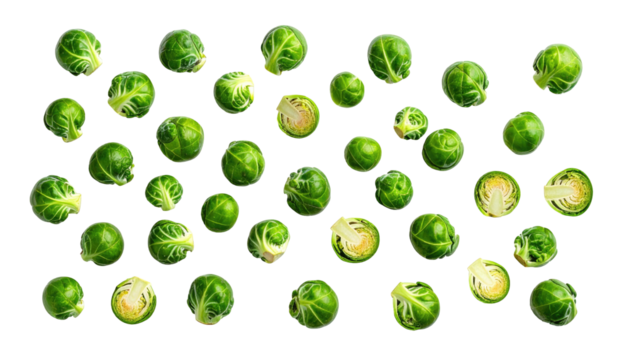 An array of verdant Brussels sprouts scattered across a plain, dark background, some sliced open revealing innards