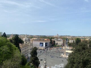 Fototapeta premium Overview of a lively square in Rome Italy with historic buildings and clear blue sky