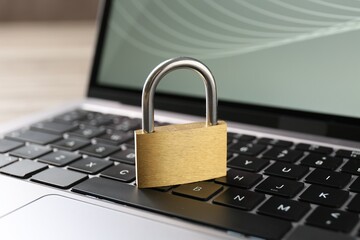 Password concept. Closed padlock and laptop on table, closeup