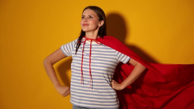 Woman wearing superhero cape on yellow background
