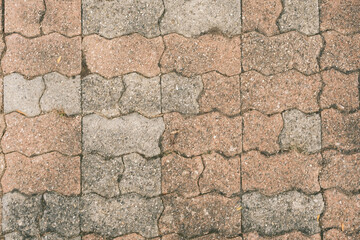 A brick walkway with a pattern of brown and gray bricks
