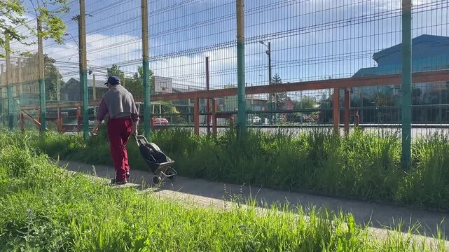 Hombre mayor caminando por la ciudad con carro de compras.