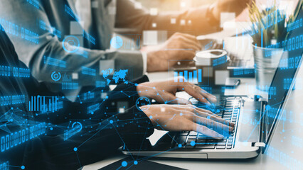 A close-up of hands typing on a laptop keyboard in a modern office setting, enhanced with digital data and analytics graphics, representing technology and business. Xenic