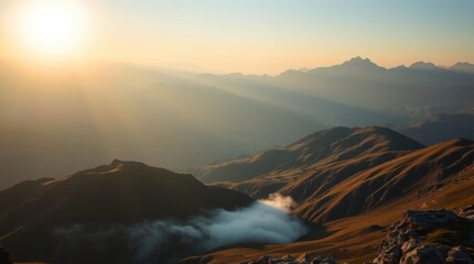 The golden morning sun casts dramatic light and sunbeams across a vast and epic mountain range with a cloud inversion in the valley