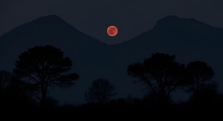 Blood moon rising over silhouette of mountains and trees at dark night