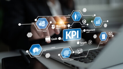 A business professional examines key performance indicators on a laptop screen, focusing on metrics...