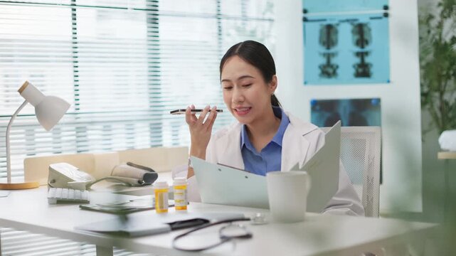 Asian female doctor holding a prescription bottle uses voice AI assistant on smartphone search for drug information. artificial intelligence in healthcare, medication verification, smart health tech.