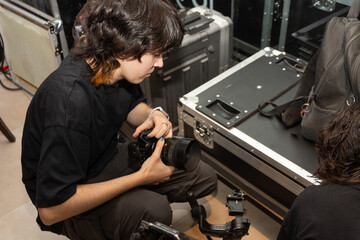 Joven camarógrafa preparando cámaras y monitor en gimbal para registro audiovisual video	