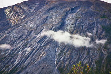 Cloud Drifting Across Rugged Mountain Face with Vegetation in Canadian Wilderness