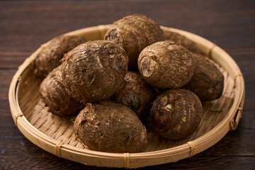 里芋（泥付き）を竹籠に盛った和風の食材カット