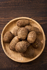 里芋（泥付き）を竹籠に盛った和風の食材カット