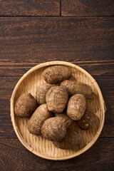 里芋（泥付き）を竹籠に盛った和風の食材カット