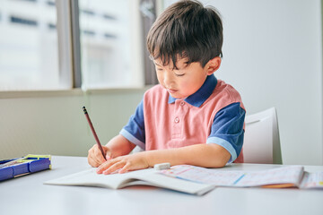 ノートに書き取りをする小学生の男の子