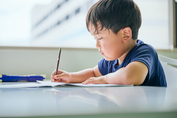 Japanese elementary school boy studying at cram school, doing homework
