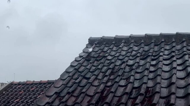 Rainstorm View from Above: Drops Splashing on Dark Terracotta Roof Tiles