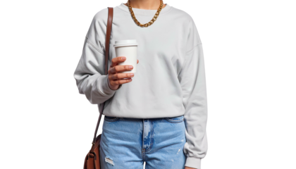 Person in casual wear holding a paper coffee cup with a shoulder bag, against black background