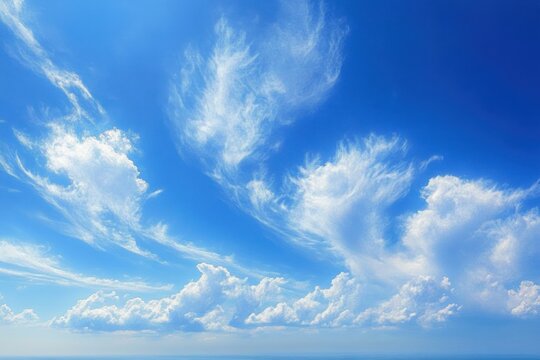 Bright blue sky filled with scattered white clouds in various shapes and sizes suggesting a calm and uplifting atmosphere