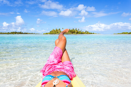 Woman with legs up in the blue lagoon of Tikehau, Polynesia
