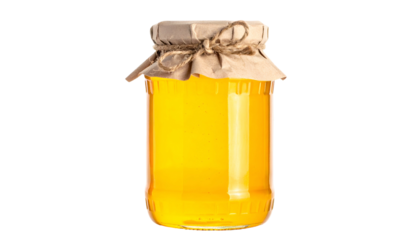 A glass jar filled with golden liquid, sealed with brown paper and twine. Dark background