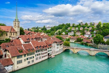 Obraz premium Explore the charm of Bern, Switzerland, with its historic buildings, red roofs, and the Aare river. A picturesque cityscape perfect for travel and cultural experiences.