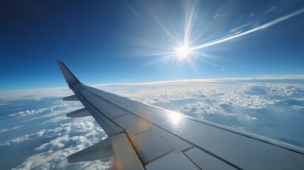 Obraz premium Wing of an aircraft illuminates brightly under intense sunlight above a vast expanse of white clouds.