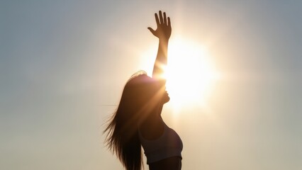 Strong confident woman! Winning and life goals concept. Silhouette of a woman reaching towards the sun against a bright sky.