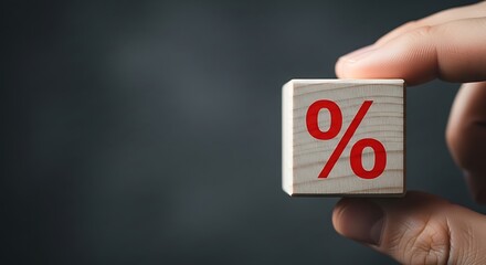 Concept of financial rates with a hand holding a wooden block with percent sign
