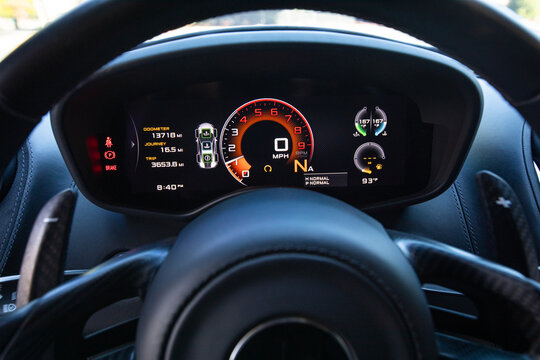 Close up of modern digital dashboard display inside a luxury sport super car. High performance cockpit showing speedometer, tachometer, and advanced driver interface with precision engineered details