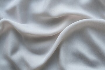 Fototapeta premium Close-up of soft, light gray fabric with gentle folds and textured surface creating smooth flowing patterns