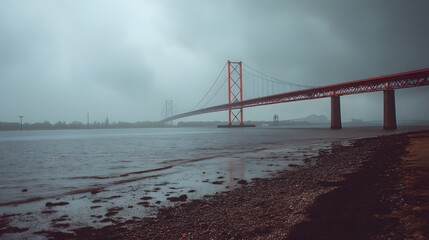 Long suspension bridge spans wide waterway under overcast sky