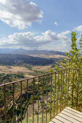 Viewpoint balcony overlooking the vast valley with mountains and fields under a blue sky with clouds in ronda, andalusia in ronda,malaga,spain