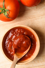 Tomato sauce for cooking Italian and Mediterranean food such as pasta and pizza, placed on a brown background