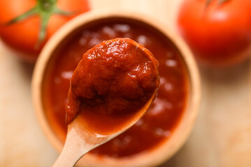 Tomato sauce for cooking Italian and Mediterranean food such as pasta and pizza, placed on a brown background