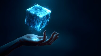 Glowing blue cube hovers above an outstretched human hand against a dark background