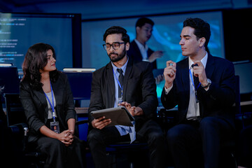 A multi-ethnic leadership team discusses digital transformation. An Indian manager presents a new AI-driven strategy for sustainable ESG goals and future market growth to his diverse team.