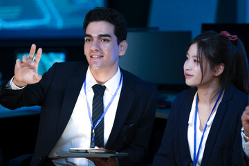 A diverse tech team discusses a new digital strategy. An Indian manager uses a tablet to show AI driven analytics for sustainable ESG growth to a colleague.