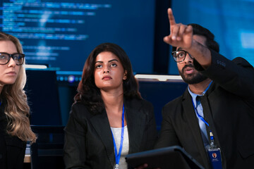 A diverse tech team discusses a new digital strategy. An Indian manager uses a tablet to show AI driven analytics for sustainable ESG growth to a colleague.