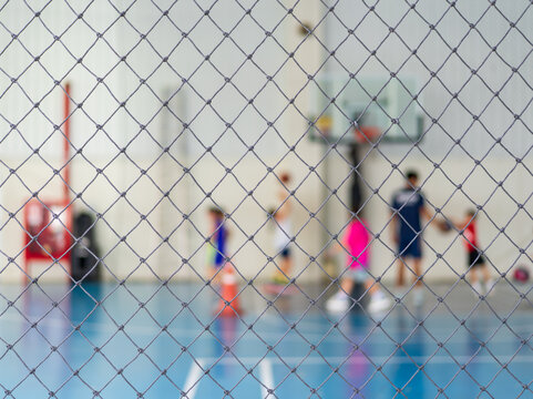 blur basketball court by rope mesh net fence focus with many youth children or kid learning training score shooting ball to playing basketball with coach and basketball hoop for sport exercise