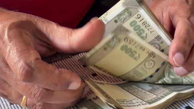 Counting Indian 500 rupees notes - Powered by Adobe