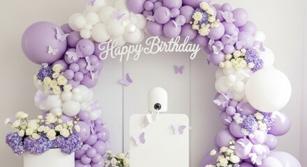 Whimsical lavender and white balloon arch with floral accents and butterflies