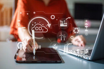 Woman using futuristic interface with smart tech and mobile to manage ESG, clean energy, and sustainability data.