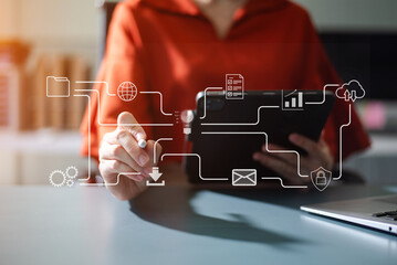 Businesswoman uses a tablet to analyze data on a virtual interface, symbolizing business innovation, technology, and global connection