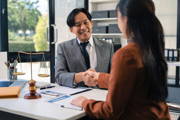 Middle age partner lawyers attorneys shaking hands after discussing a contract agreement done.