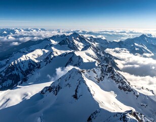 Aerial view of snow-capped mountain peaks rising above cloud cover