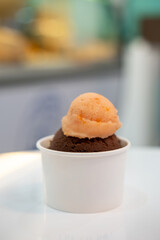 A cup of Gelato, Chocolate and tomato Ice-cream on the table with blur background.