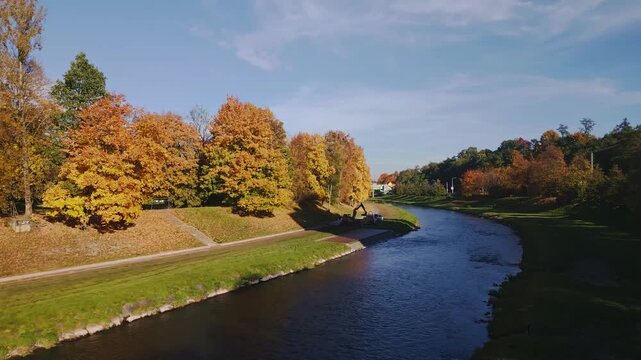 Colourful golden autumn trees line River Ostravice in Komensk&yacute; Park