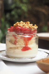 Dessert in a glass with strawberries and nuts at a cafe