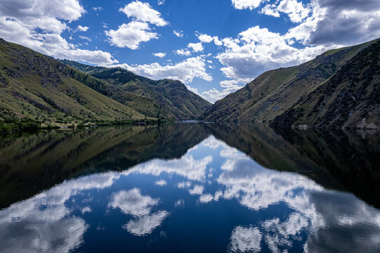 Drone photo of calm surface of Snake river, Hells Cayon. Clouds reflection in blue water